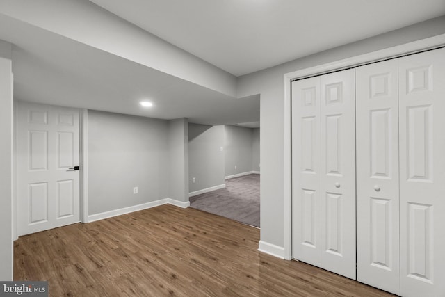 basement with baseboards and wood finished floors