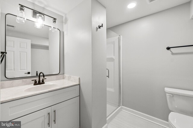 full bath featuring visible vents, baseboards, toilet, a stall shower, and vanity