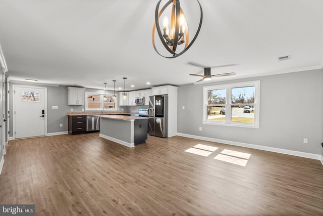 kitchen with visible vents, appliances with stainless steel finishes, a center island, and open floor plan