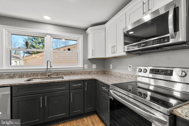 kitchen featuring white cabinets, a healthy amount of sunlight, appliances with stainless steel finishes, and a sink