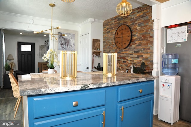 kitchen featuring hanging light fixtures, dark wood-type flooring, blue cabinetry, and crown molding