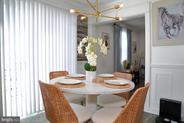 dining area featuring a wealth of natural light, ornamental molding, an inviting chandelier, and wood finished floors