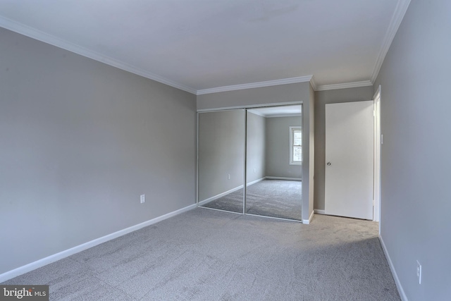 unfurnished bedroom with a closet, baseboards, crown molding, and carpet