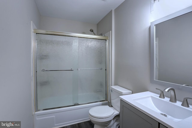 full bath featuring enclosed tub / shower combo, toilet, and vanity