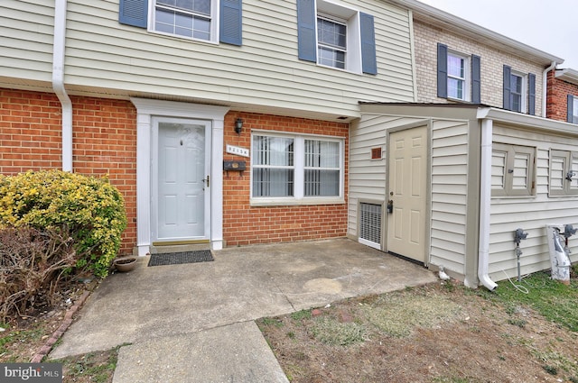 doorway to property with brick siding