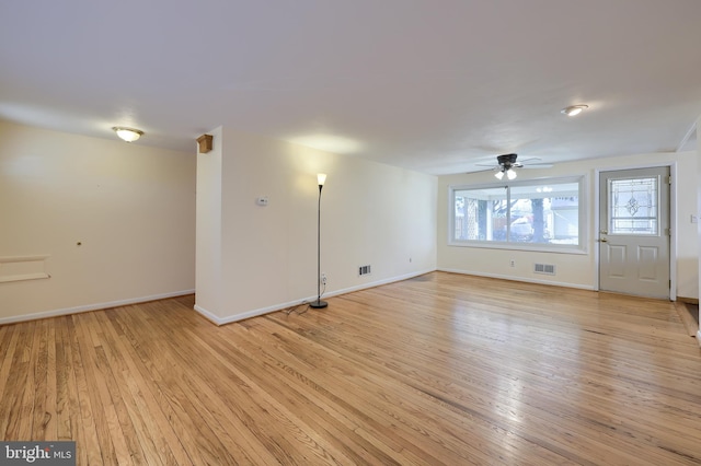 interior space featuring light wood-style flooring, baseboards, visible vents, and ceiling fan