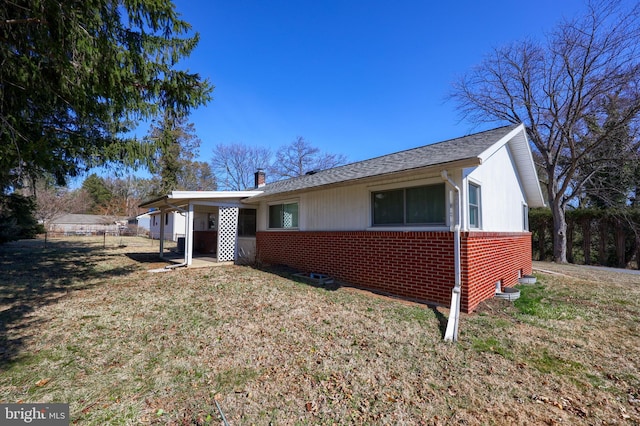 view of front facade featuring brick siding, a chimney, and a front lawn