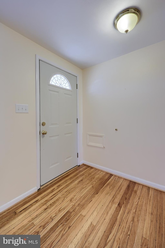 foyer with baseboards and light wood-style floors