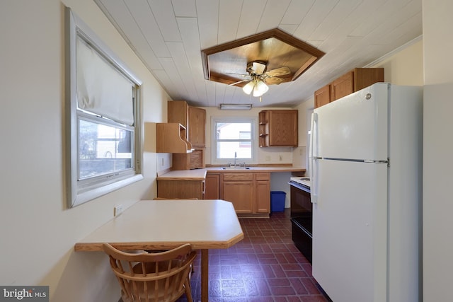 kitchen featuring a sink, light countertops, freestanding refrigerator, electric range, and open shelves