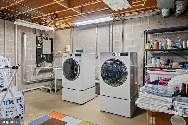 laundry room with electric panel, separate washer and dryer, and laundry area