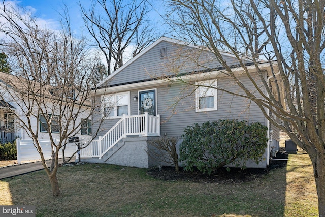 view of front facade featuring cooling unit and a front yard