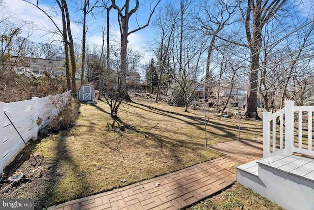 view of yard featuring an outbuilding, a fenced backyard, and a shed