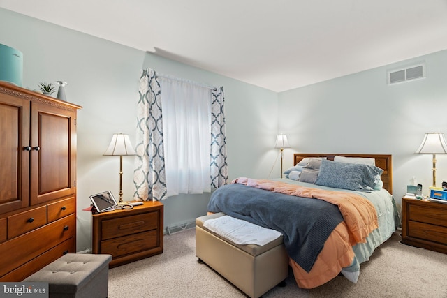 bedroom featuring visible vents and light carpet