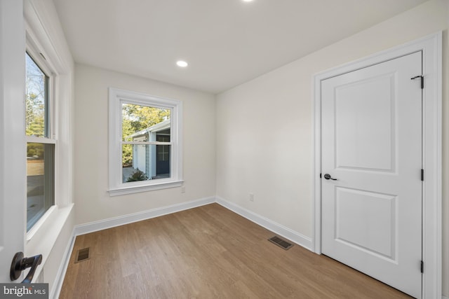 unfurnished room with visible vents, baseboards, and wood finished floors