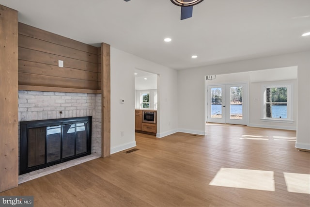 unfurnished living room featuring visible vents, light wood-style flooring, recessed lighting, a fireplace, and baseboards