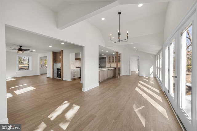 unfurnished living room featuring a wealth of natural light, light wood-style flooring, and a large fireplace