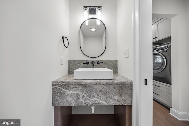 bathroom with washer / dryer, wood finished floors, and vanity