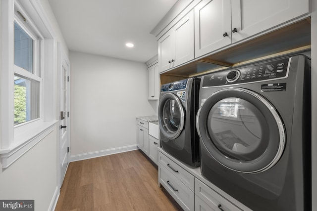 washroom featuring baseboards, light wood finished floors, cabinet space, recessed lighting, and washing machine and dryer