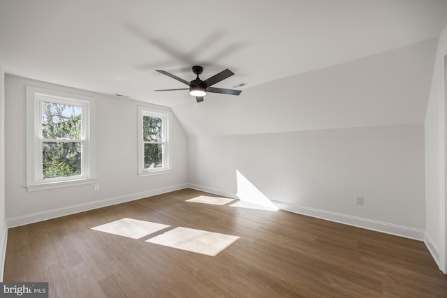 additional living space with visible vents, baseboards, wood finished floors, and vaulted ceiling