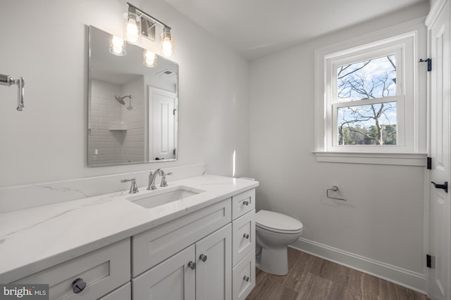 full bath with vanity, wood finished floors, baseboards, a shower, and toilet