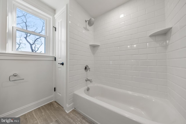 full bath featuring baseboards, wood finished floors, and shower / bathtub combination