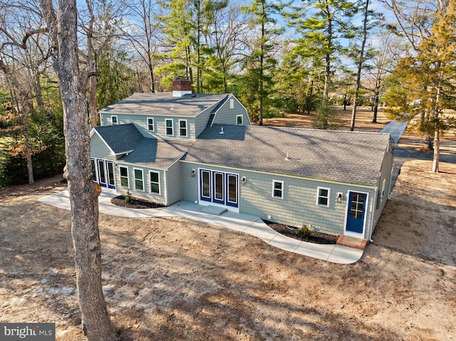 back of property with a patio area, a chimney, and roof with shingles