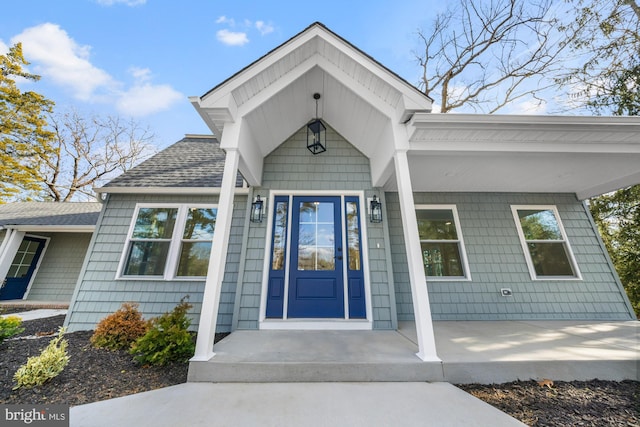 property entrance featuring a shingled roof