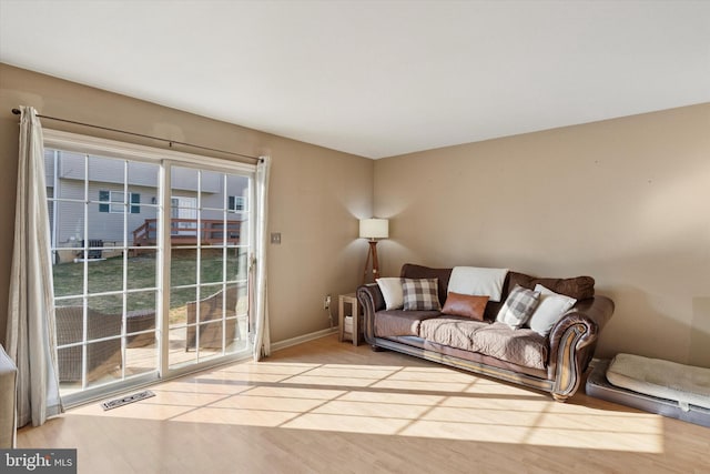 living room with visible vents, baseboards, and wood finished floors