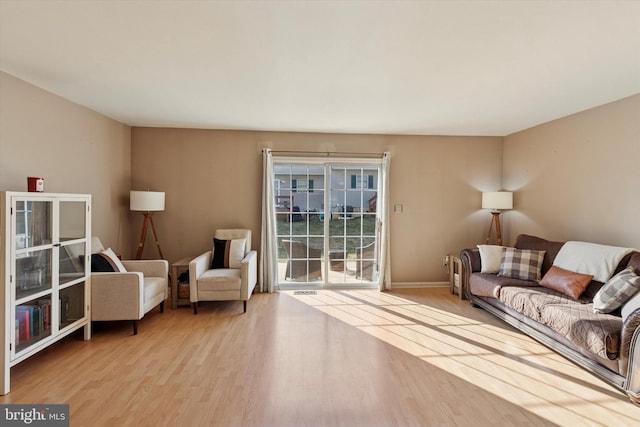 living area featuring baseboards and wood finished floors