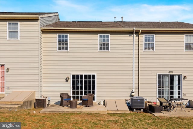 back of property featuring cooling unit, a yard, and a patio area