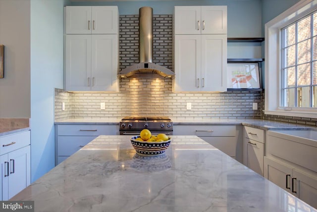 kitchen with open shelves, wall chimney exhaust hood, white cabinets, range with gas cooktop, and decorative backsplash