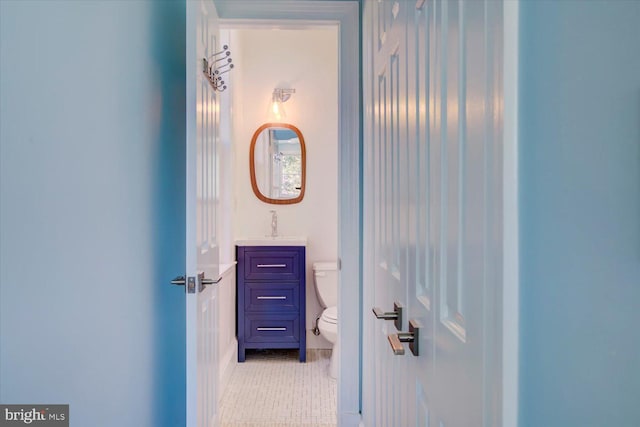bathroom with toilet, tile patterned floors, and vanity