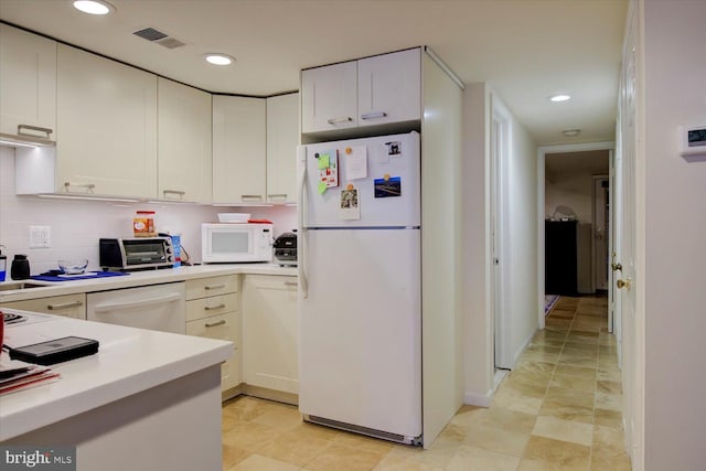 kitchen with light countertops, visible vents, a toaster, and white appliances