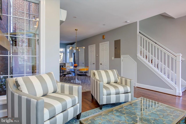 living room with stairs, wood finished floors, and a chandelier