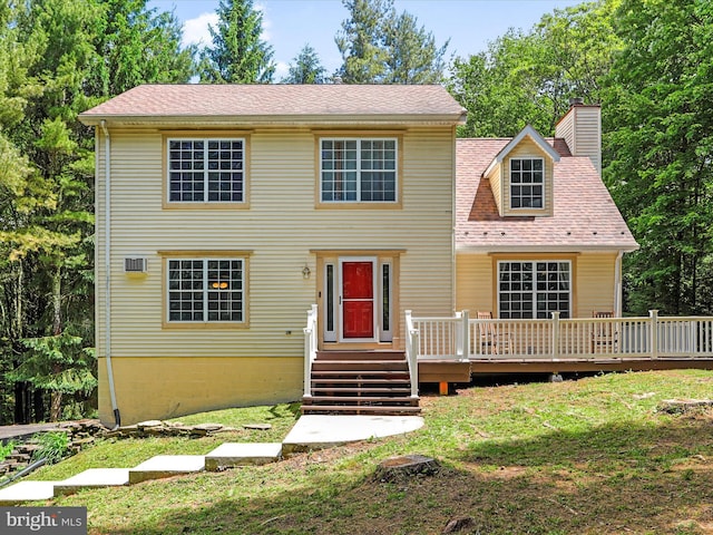 view of front of property featuring a wooden deck, a front lawn, and a chimney