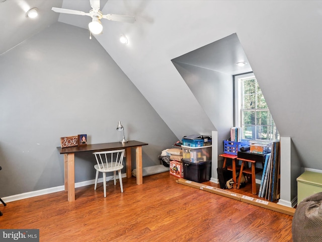 office area featuring vaulted ceiling, a ceiling fan, baseboards, and wood finished floors