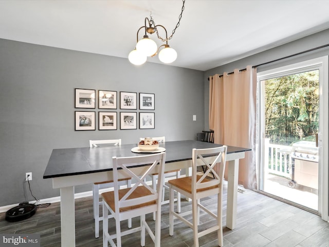 dining area with a chandelier, baseboards, and wood finished floors