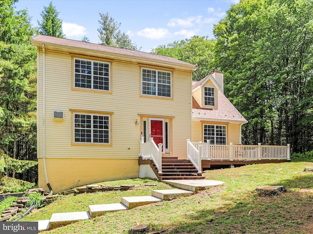 view of front of property with a wooden deck, a front lawn, and a chimney