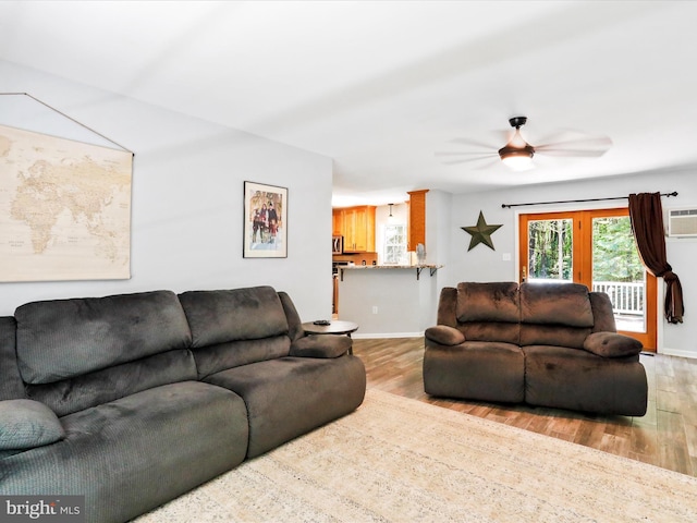 living room with light wood-type flooring, baseboards, and a ceiling fan