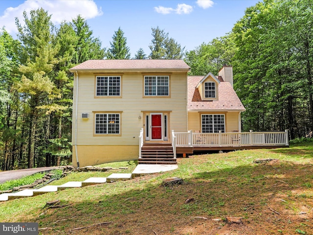 view of front of property featuring a front lawn, a deck, and a chimney