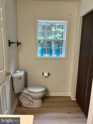 bathroom featuring toilet, wood finished floors, and baseboards