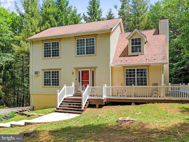 view of front facade with a deck, a front lawn, and a chimney