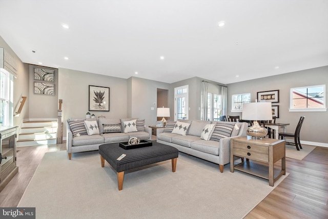 living room with light wood finished floors, stairway, plenty of natural light, and recessed lighting