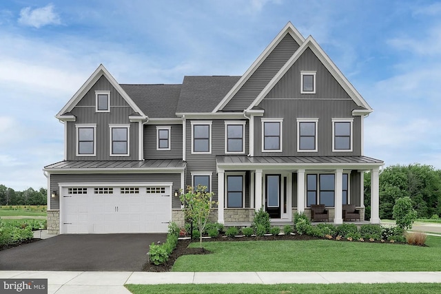 view of front of house featuring a front lawn, a standing seam roof, stone siding, board and batten siding, and covered porch