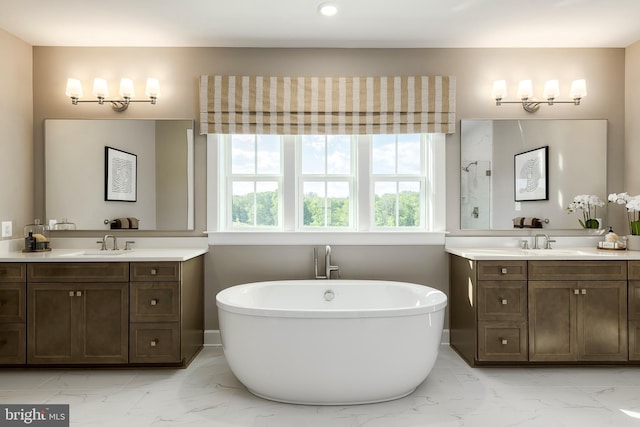 full bathroom featuring a sink, a soaking tub, and marble finish floor