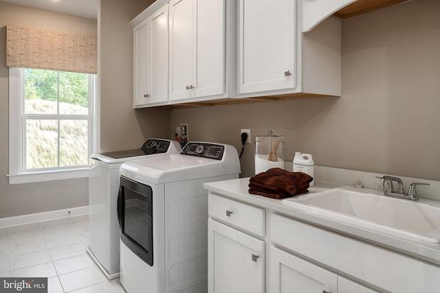 laundry area featuring baseboards, cabinet space, a sink, washing machine and dryer, and marble finish floor