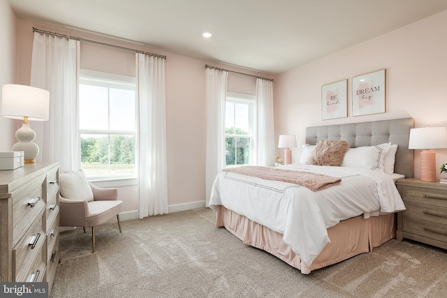 bedroom featuring light carpet, recessed lighting, multiple windows, and baseboards