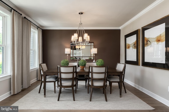 dining space with baseboards, an inviting chandelier, wood finished floors, and ornamental molding