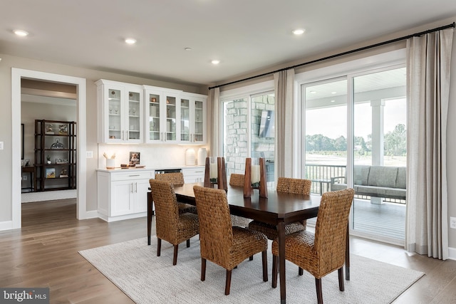 dining space with light wood-style flooring, recessed lighting, and baseboards