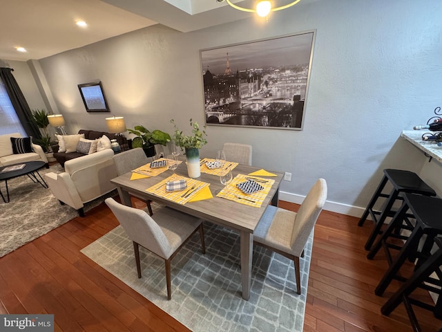 dining space with baseboards and wood-type flooring